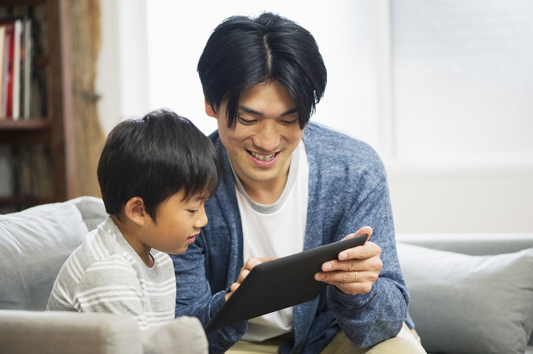 Father showing son something on a tablet computer