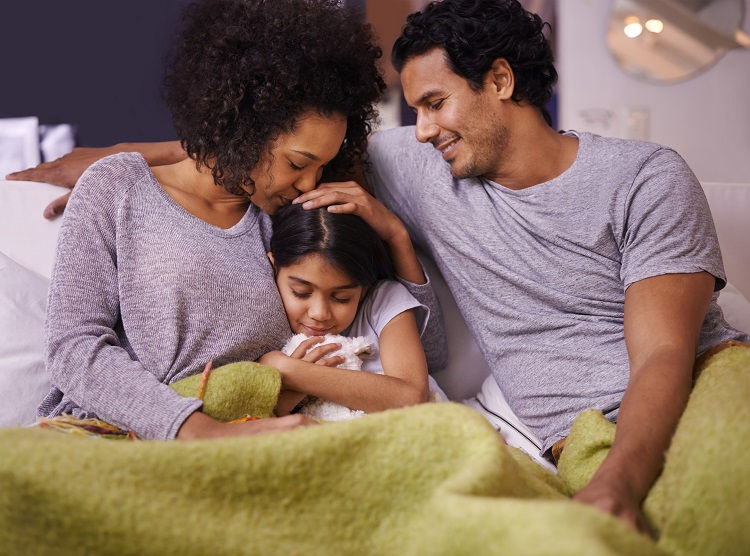 Family cuddling under a blanket