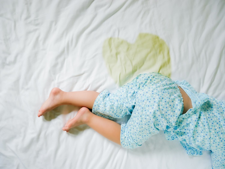 Child with urine spot on the bed